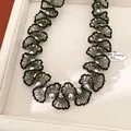 Gros plan détaillé d'un élégant collier en dentelle de perles et de perles de verre - Collier / Grand / Noir