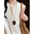 Close-up detail of Maillard style irregular long necklace with natural wooden and bead accents - White & Dark Coffee
