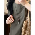 Detailed view of an irregular Maillard style long necklace with a unique wood pendant - Coffee, Black & Silver