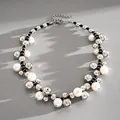 Detail of retro white pearl and silver bead necklace on grey background with shadows - Silver-Black