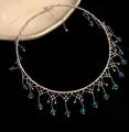 Elegante zilveren kralen choker met blauwe kristallen franjes op zwarte achtergrond. - Blauw Kristal / Zilver