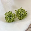 Vue détaillée de boucles d'oreilles fleurs en zircone verte sur tissu blanc texturé. - Style 17# / Tige d'oreille en argent-Vert