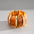 Detail van retro geometrische acryl armband met amber marmerpatroon en goud metaal. - Ruitvormige Gesplitste Armband / Donker koffiebruin
