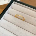 Gros plan détaillé d'une bague ondulée plaquée or 18 carats avec des oxydes de zirconium - Bague Vague en Zirconium / Or