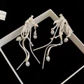 Macro-weergave van unieke zilveren tak-oorbellen met witte parels en een organisch modern ontwerp - Gestroomlijnde Takparel (25#)