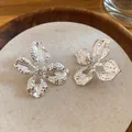 Minimalistische zilverkleurige bloemknopjes met kristallen hart op beige stoffen tray - Gehamerde Strassbloem (35#)