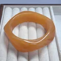 Elegant amber marbled resin bangle featuring a unique curved wave design for women - Orange Swirl