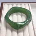 Elegant green resin bangle bracelet featuring a unique irregular geometric curved design - Emerald Green with White Swirl