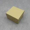 Close-up detail of a champagne gold square jewelry gift box with a lid and base - Bed Pillow / Kraft Yellow