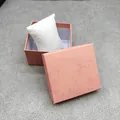 Detailed view of a pink textured jewelry gift box with a white pillow inside - Bed Pillow / Pink