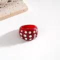 Dettaglio di un anello in resina rossa lucida con strass trasparenti scintillanti - Anello / Rosso