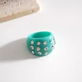Primo piano di un anello in resina turchese con dettagli in strass scintillanti. - Anello / Ciano