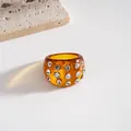 Detailed close-up of a chunky amber resin ring embedded with sparkling white rhinestones - Ring / Brown
