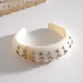 Elegante bracciale rigido in resina bianca con borchie in metallo argento e venature ambra - Bangle / Avorio