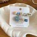 Nahaufnahme süßer Haarklammern mit Strassschleife und Hundemotiv auf einer Karte. - Entenschnabelklemme (HH9884) / Ein Paar / Weiß-Blau