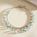 Dettaglio ravvicinato di collana girocollo argentata con frange di cristallo blu chiaro - Collare Argento con Cristallo Blu / Argento