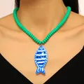 Dettaglio della collana con ciondolo a pesce tropicale e catena di perline verdi vivaci - Collana di perline / Verde
