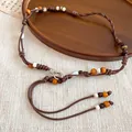 Exclusief detailoverzicht van de bohemian vintage kralen tailleketting met houten accenten - Bruin