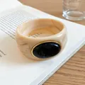 Close-up of minimalist marbled acrylic bangle with oval black stone centerpiece - Ivory-Black
