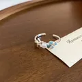 Detailaufnahme eines offenen Seesternrings mit weißer Perle und blauem Emaille-Anhänger - Delfin-Perlen-Stern-Stil (31#) / Silber Blau