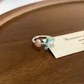 Macro-opname van een zomerse blauwe zeester ring met emaille op een rustiek houten dienblad - Gradiënt Emaille Zeester Open Ring (28#) / Zilver-Blauw