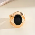 Vue détaillée d'un bracelet manchette doré avec une grande pierre noire ovale chic - Bracelet Rigide - Design Creux / Or-Noir