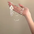 Detail shot of a handmade multilayer glass bead flower necklace with delicate tassels. - Multi-layer Flower Choker / White