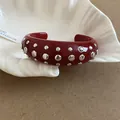 Close-up of a red resin cuff bracelet featuring silver round studs in punk style - Style 54