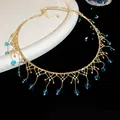 Detailansicht eines eleganten Gold-Chokers mit lebhaften blauen Kristalltropfen für Damen. - Halsband-Gold-Blau