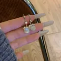 Elegant silver hook earrings featuring a round cat eye stone pendant and sparkling crystals - Silver