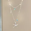 Detailed view of silver double-layer necklace with starfish pendants and blue crystal - Silver