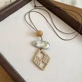 Close-up view of bohemian long necklace with woven diamond pendant and marble bead texture - Rhombus (5# Necklace) / Brown