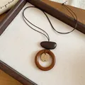 Detailed view of bohemian wooden ring necklace with flower bead on a tray - Sunflower (1# Necklace) / Brown