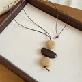 Detail of a bohemian necklace with woven heart beads and a smooth brown center stone. - Heart (6# Necklace) / Brown