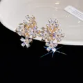 High-quality close-up of sparkly zirconia flower clip-on earrings on a white ceramic plate - 3# Ear Clip-Gold