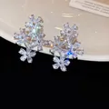 Close-up of elegant sparkling zircon flower clip-on earrings on a white ceramic plate - 4# Ear Clip-Silver
