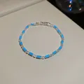 Detailansicht eines Silber-Zirkonia-Armbands mit blauen Steinen auf beigem Grund. - Rechteckiger Blauer Koreanischer Stil (55#)