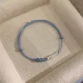 Detailed macro view of the minimalist blue braided bracelet featuring a silver fish charm - Fish Pendant Bracelet Set (Blue)