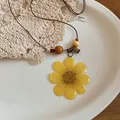Detail view of a yellow preserved flower pendant necklace with wooden beads and leather cord - Yellow Dried Tulip Style (33#) / Yellow