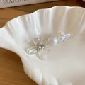 Close-up of elegant hair clip with transparent flower, pearls, and rhinestones on shell plate. - Duckbill Clip - Single / Transparent Flower (Pearl)