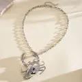 Primer plano detallado de un collar con colgante de cangrejo de metal plateado brillante - Collar / Plateado
