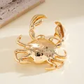 Primer plano detallado de un colgante de cangrejo de metal dorado pulido para collar - Broche / Dorado