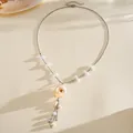 Close-up of elegant shell rose pendant and pearl beads on silver chain necklace. - Silver White