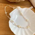 Dettaglio di una collana estiva con ciondoli a stella marina ed eleganti perline. - Collana-Bianco / Bianco