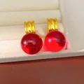 Gros plan de sphères en résine rouge vibrant avec des anneaux dorés minimalistes modernes - Rouge