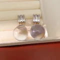 Détail macro de boucles d'oreilles rondes en résine translucide colorée avec créoles. - Transparent