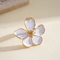 Detailed macro shot of a white enamel flower ring with gold metal edges and stamen - White