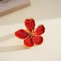 Detailed macro view of a red enamel flower ring with elegant gold metallic edges. - Red