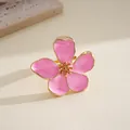 Detailed close-up of a pink enamel flower ring with elegant gold-tone metal petals for women - Pink