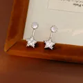 Detailed view of elegant silver stud earrings featuring round and star-shaped zircon stones - Silver